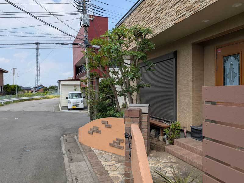 シマトネリコの剪定後。高さを抑えて透かし剪定を行い、建物の壁が見えるほど風通しが良く、すっきりと明るい印象になった玄関脇。